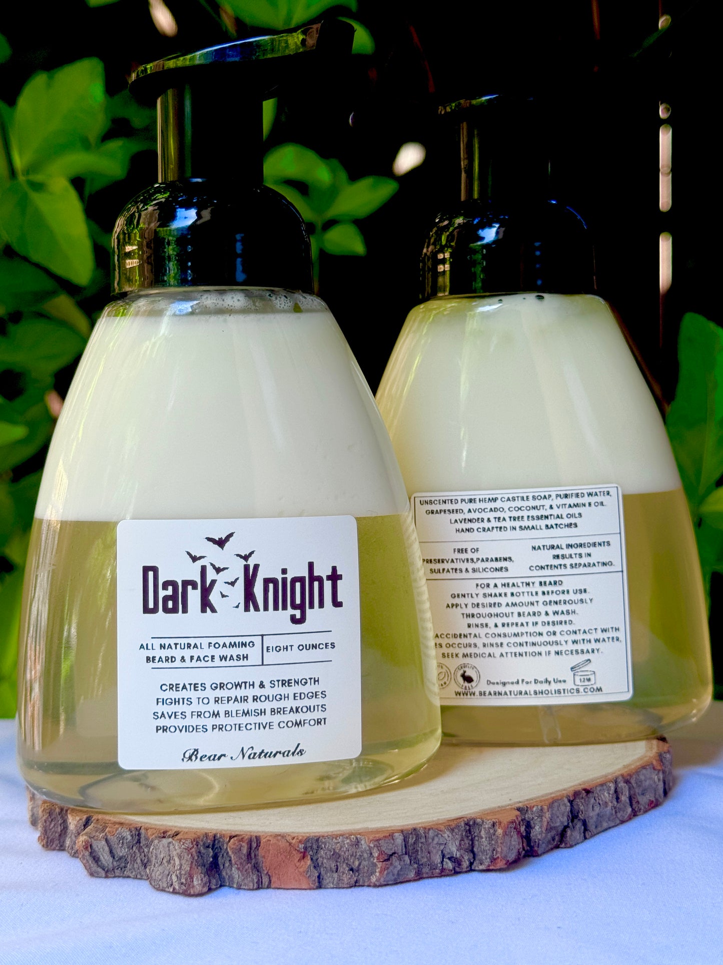 Two 8 ounce bottles of 'Dark Knight' all natural beard wash product on a wooden block with a natural background