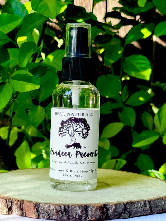 A clear bottle with a black fingertip style spray nozzle featuring a white label with black writing on a wooden surface with green leaves in the background.