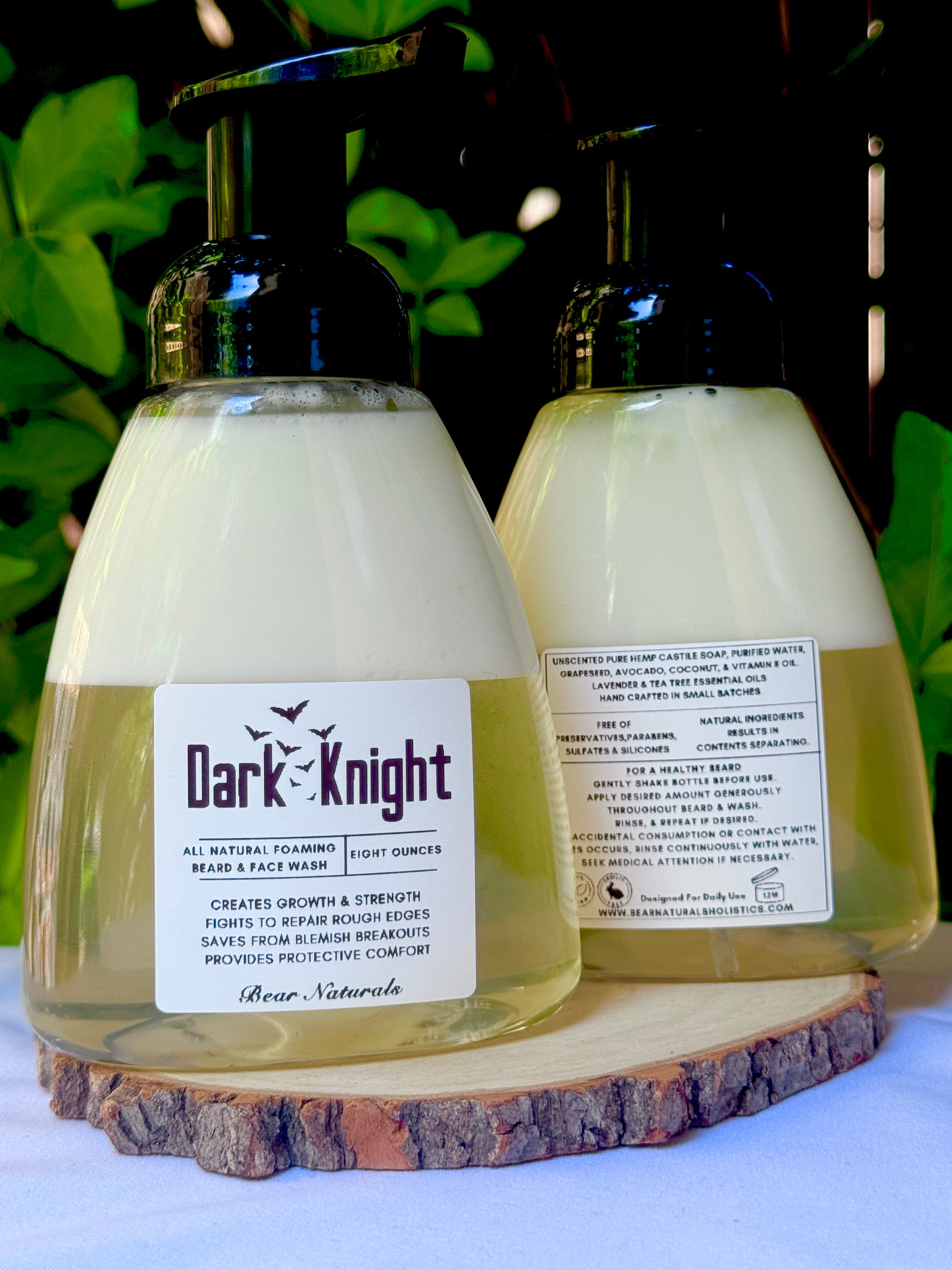 Two 8 ounce bottles of 'Dark Knight' all natural beard wash product on a wooden block with a natural background