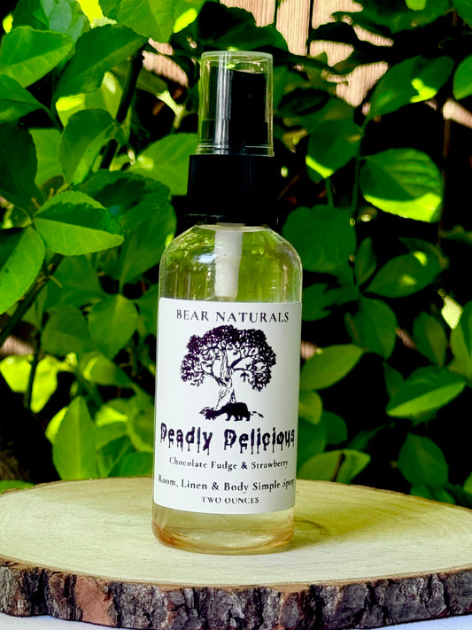 A clear bottle with a black fingertip style spray nozzle featuring a white label with black writing on a wooden surface with green leaves in the background.